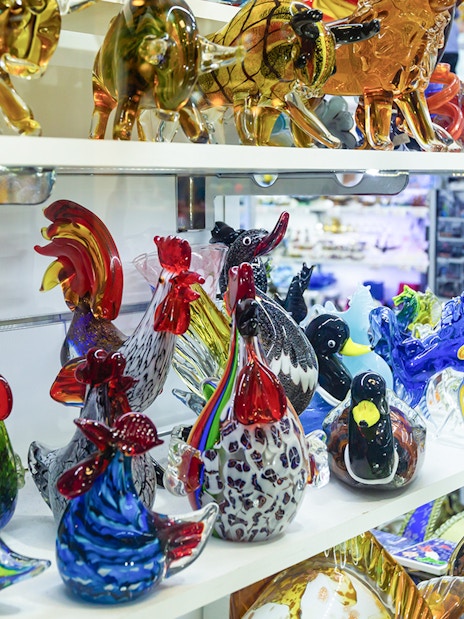Murano glass animal figurines on display shelf in Venice, Italy.