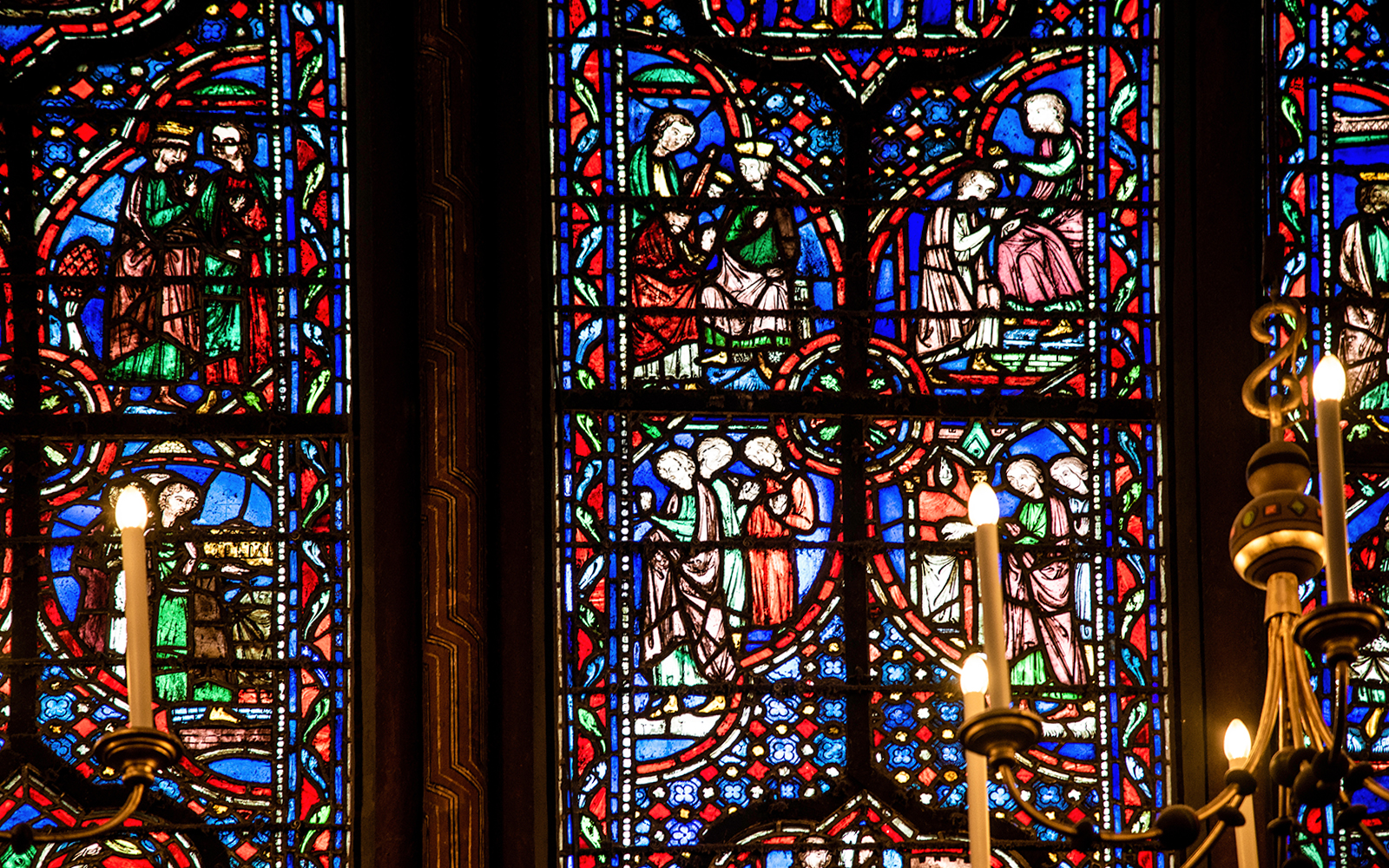 Stained glass window in Sainte-Chapelle, Paris, featuring blue, orange, and red colors.