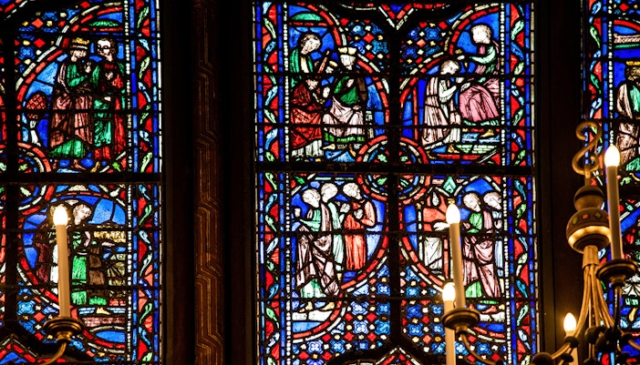 Stained glass window in Sainte-Chapelle, Paris, featuring blue, orange, and red colors.