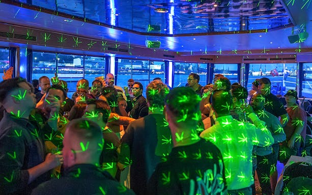 Partygoers enjoying a laser-lit boat party on the Elbe River in Hamburg.