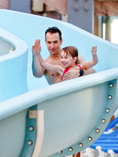 Father and daughter enjoying a waterslide at Aquaboulevard de Paris.