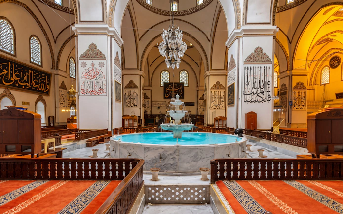 Bursa Grand Mosque interior with central fountain and ornate calligraphy, Istanbul tour.