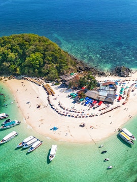 Tourists exploring historic street with yellow buildings in a European city.