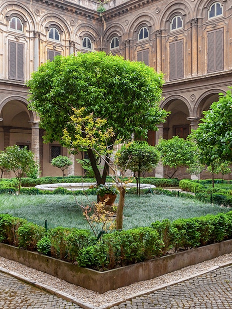Doria Pamphilj Courtyard with lush greenery and historic architecture in Rome.