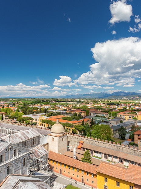 Panoramic view of Pisa cityscape from the top of the Leaning Tower, featuring the cathedral dome.