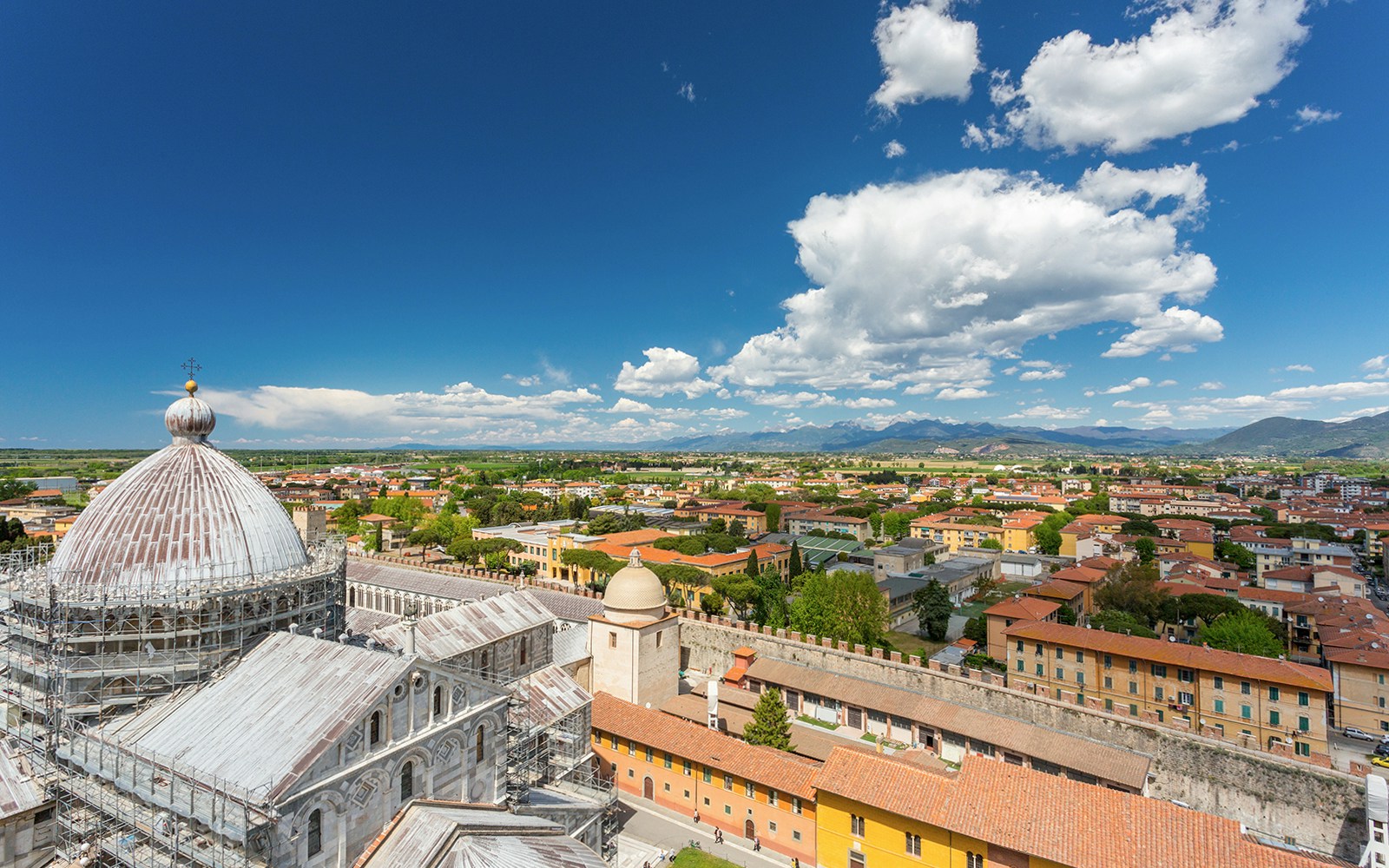 Panoramic view of Pisa cityscape from the top of the Leaning Tower, featuring the cathedral dome.