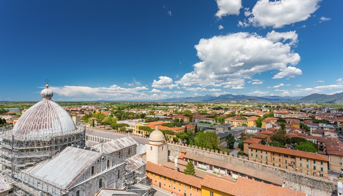Panoramic view of Pisa cityscape from the top of the Leaning Tower, featuring the cathedral dome.