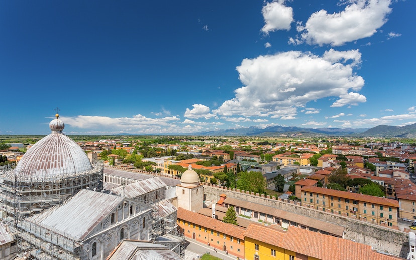 Panoramic view of Pisa cityscape from the top of the Leaning Tower, featuring the cathedral dome.
