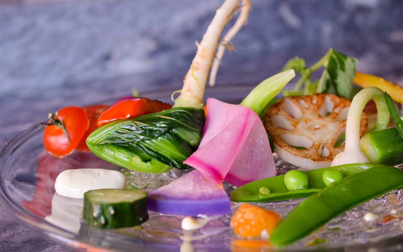 Assorted fresh vegetables on a glass plate at Akasaka NonTitle, Tokyo.