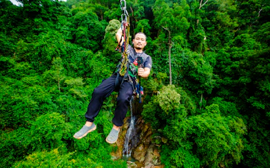 Ziplining through lush forest canopy in Koh Samui, Thailand.