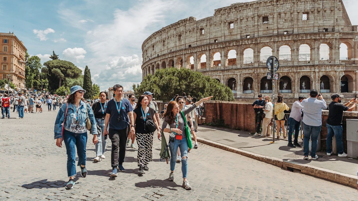 Tour guide leading group near Colosseum in Rome.