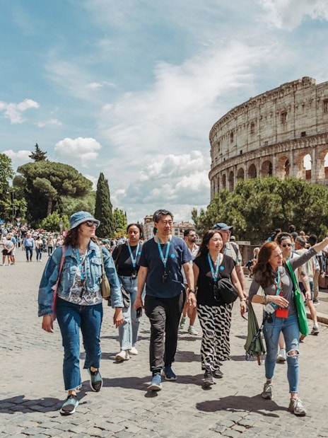 Tour guide leading group near Colosseum in Rome.
