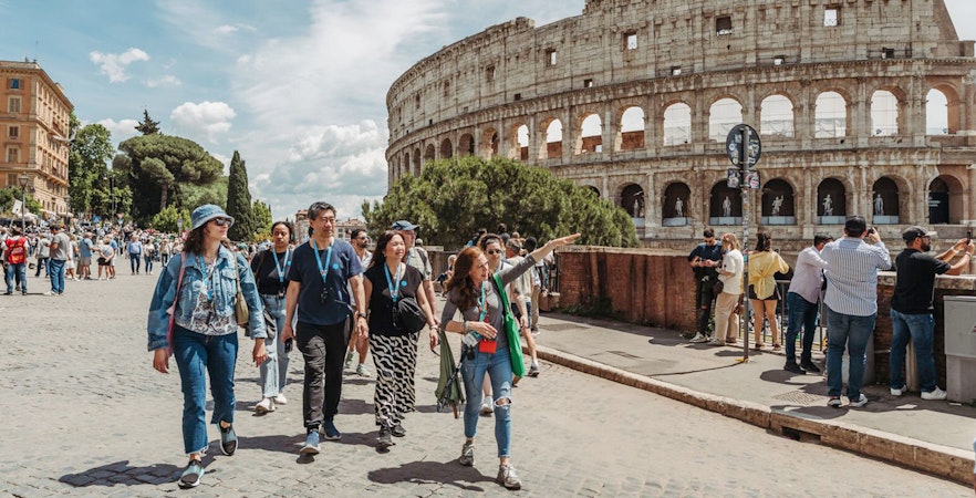Tour guide leading group near Colosseum in Rome.