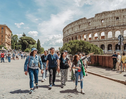 Tour guide leading group near Colosseum in Rome.
