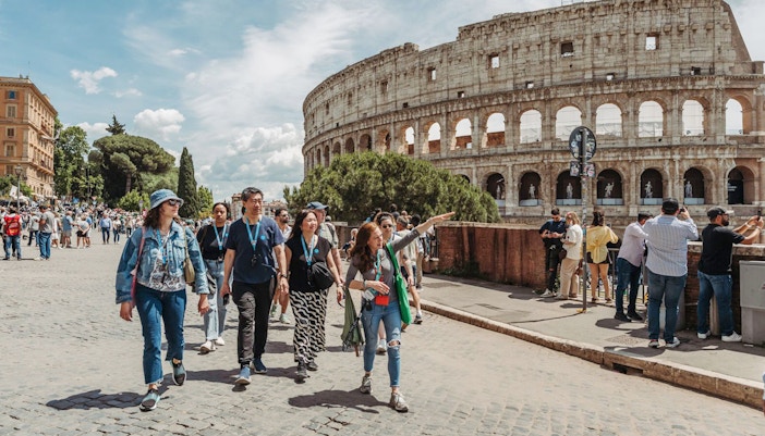 Tour guide leading group near Colosseum in Rome.
