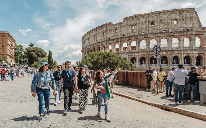 Tour guide leading group near Colosseum in Rome.