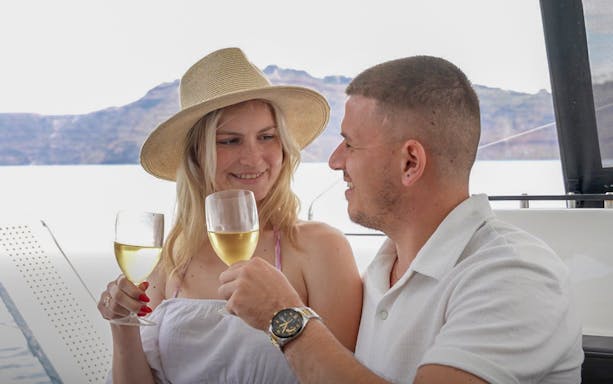 Guests toasting with wine on a Santorini catamaran cruise.