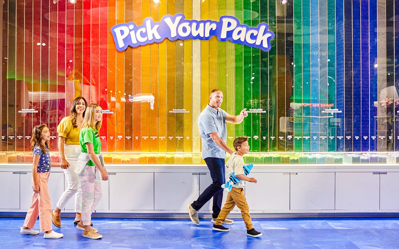 Family exploring Crayola Crayon Wall at Crayola Experience, Mall of America.