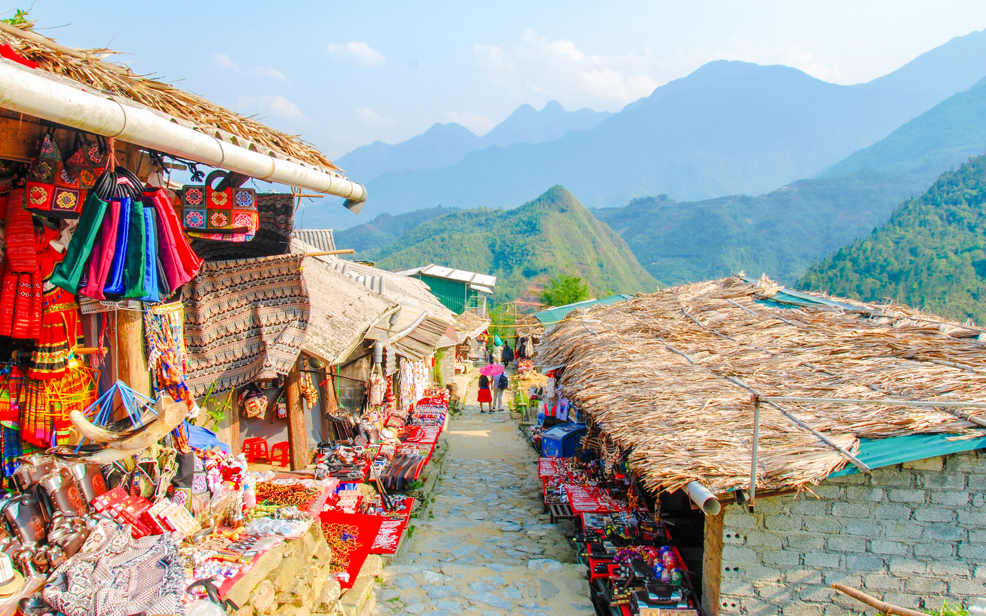 Street market in Cat Cat Hmong village, Sapa, Vietnam, displaying colorful traditional clothes.