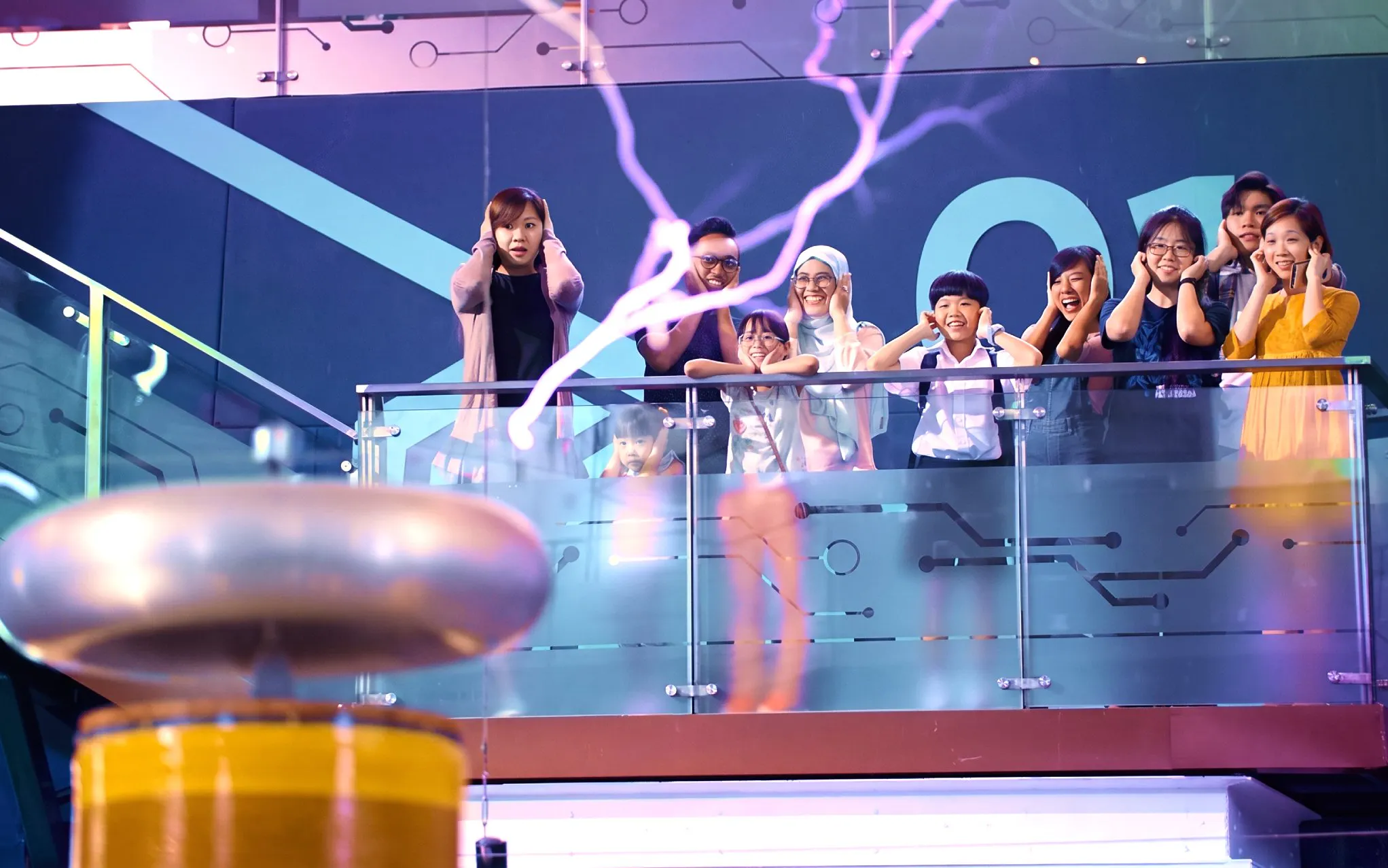 Visitors observing a Tesla coil demonstration at Science Centre Singapore.