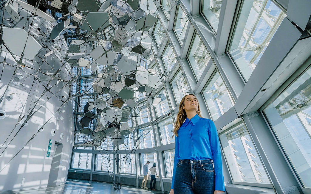 Person exploring the interior of Mirador Torre Glòries, Barcelona with geometric art installation.