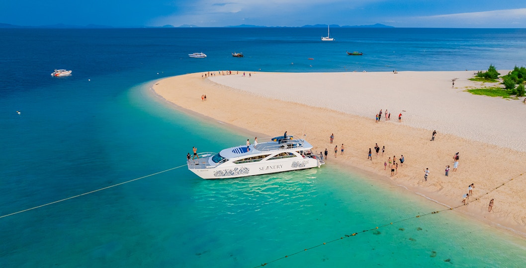 Seanery catamaran near Bamboo Island with tourists enjoying the clear blue waters.