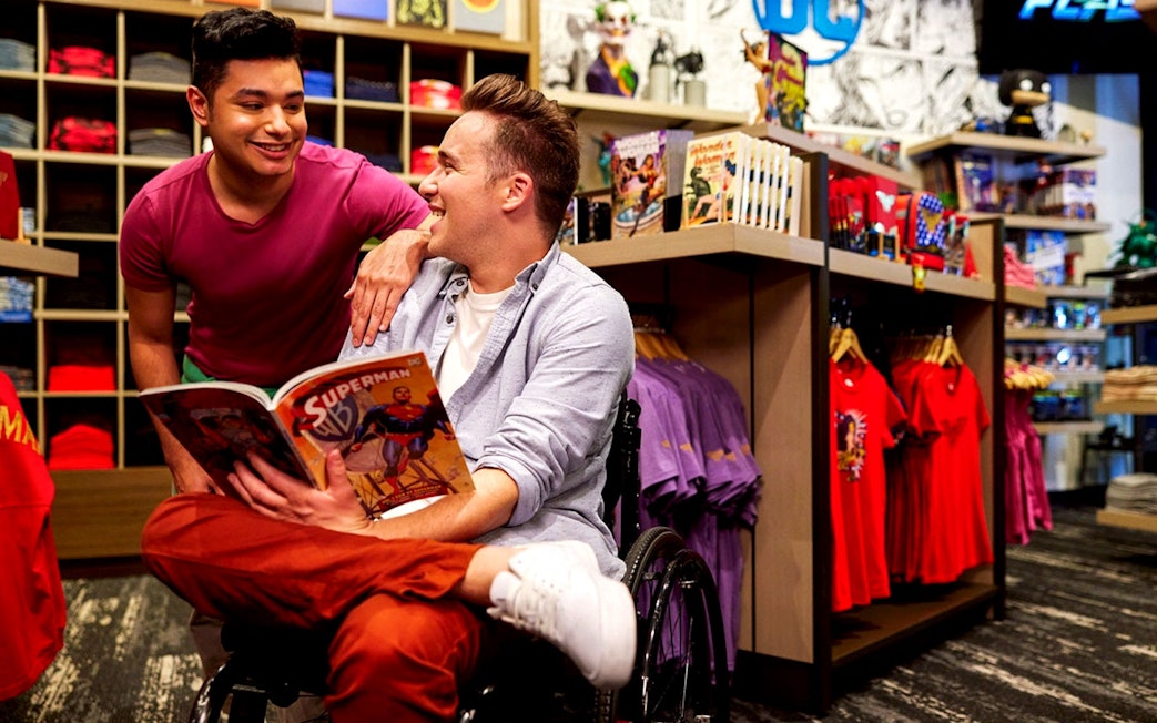 Two individuals enjoying a comic book at Warner Bros Studio Tour Hollywood gift shop.