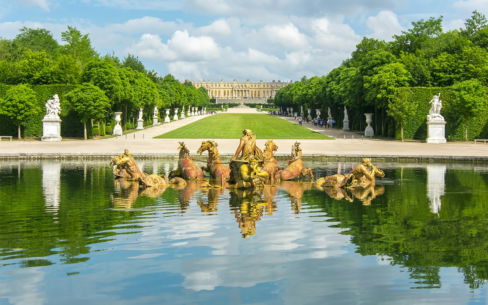 Apollo fountain in Versailles Palace Gardens with palace in background.