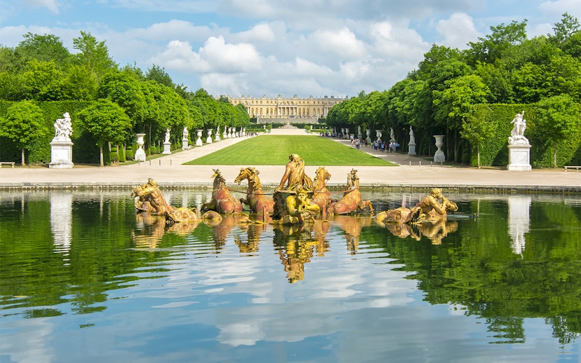 Apollo fountain in Versailles Palace Gardens with palace in background.