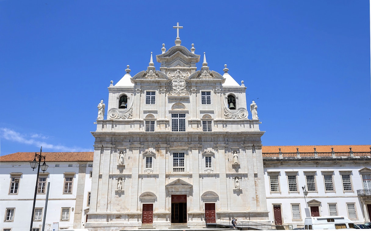 Se Nova Cathedral facade in Coimbra under clear blue sky.