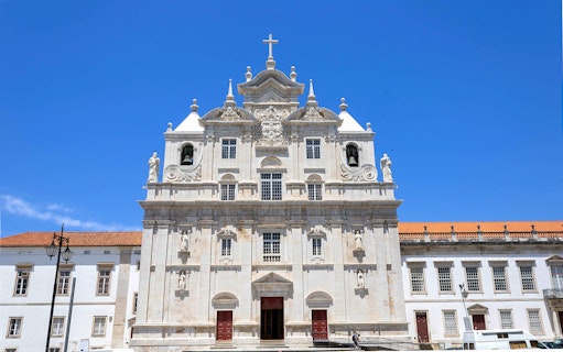 Se Nova Cathedral facade in Coimbra under clear blue sky.