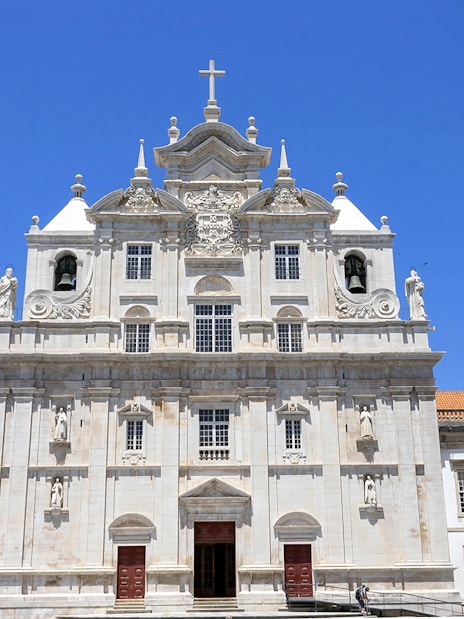 Se Nova Cathedral facade in Coimbra under clear blue sky.