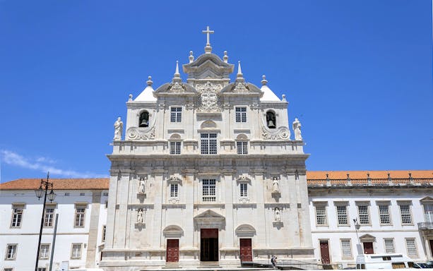 Se Nova Cathedral facade in Coimbra under clear blue sky.