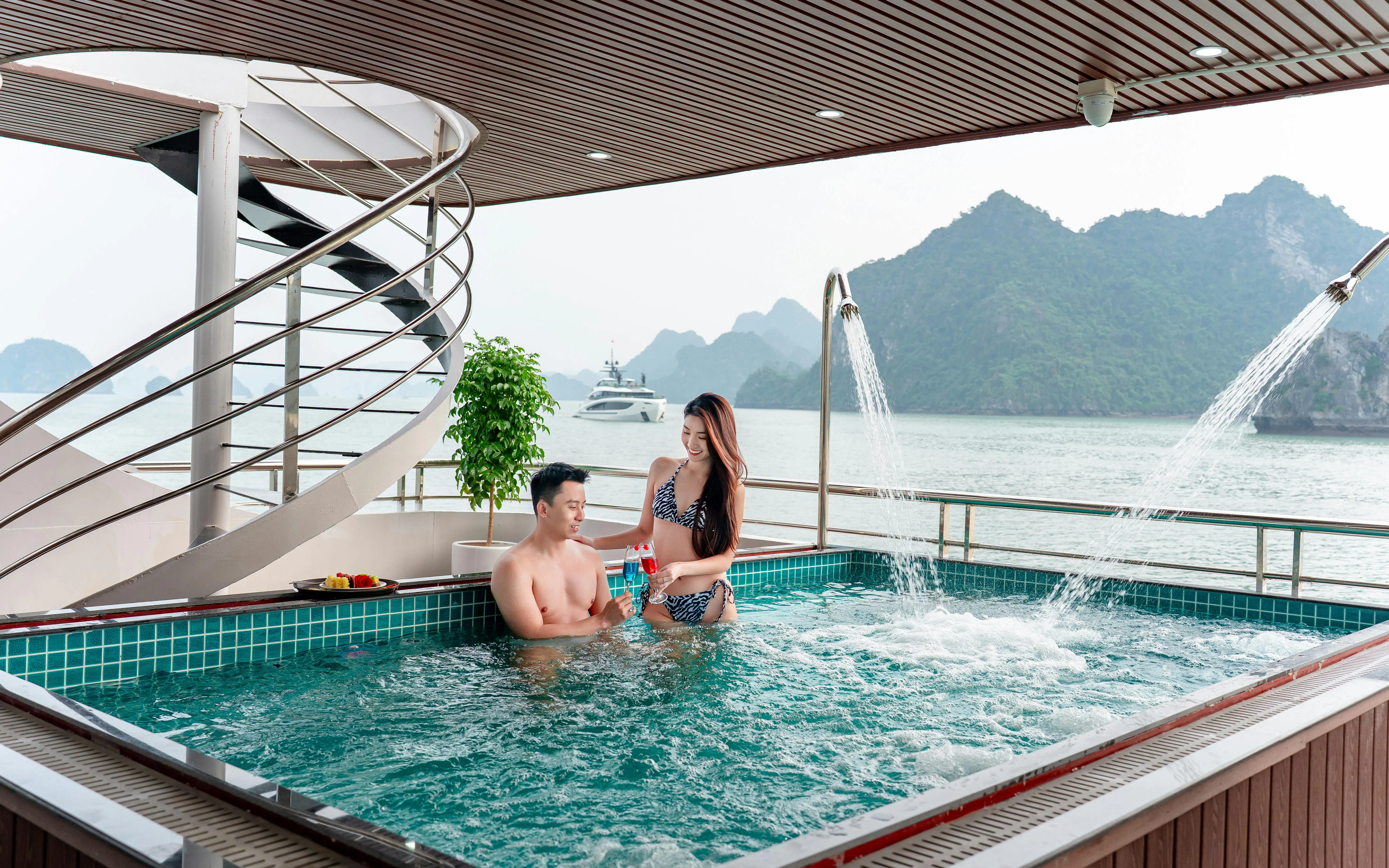 Couple enjoying a jacuzzi on a luxury cruise with Ha Long Bay view.