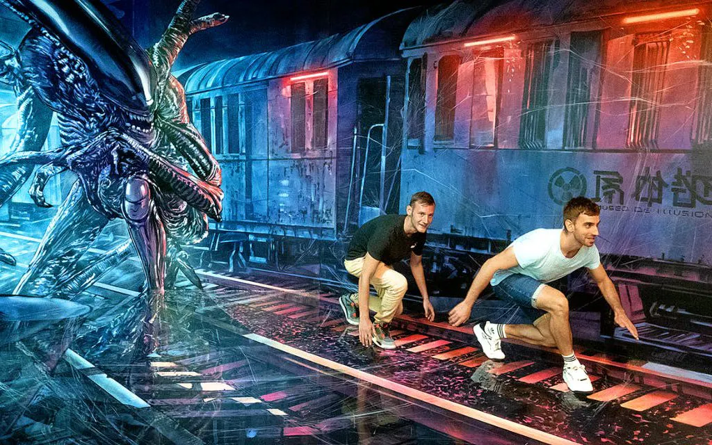 Visitors interact with an alien-themed illusion at Big Fun Museum & Museum of Illusions.