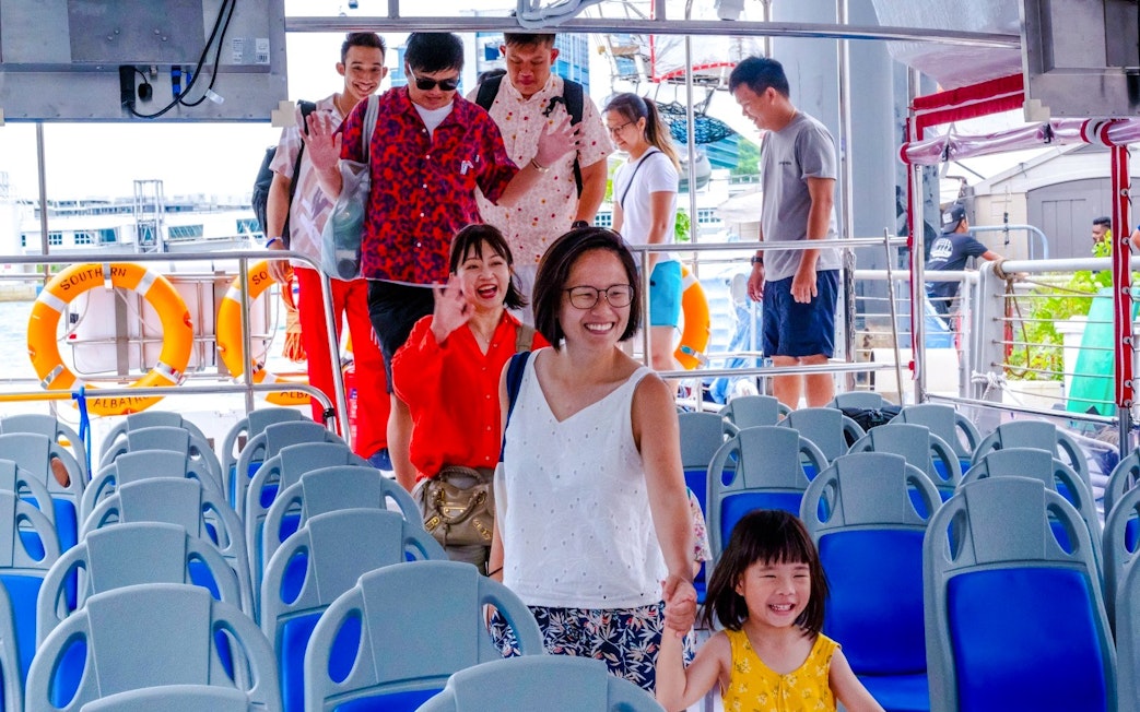 Tourists boarding Albatross Hop-On Hop-Off Speedboat at the dock.