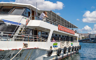 Tourists on a boat enjoying the Istanbul Bosphorus sightseeing cruise with an audio guide.