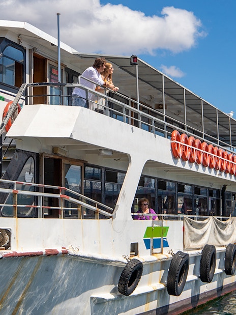 Tourists on a boat enjoying the Istanbul Bosphorus sightseeing cruise with an audio guide.