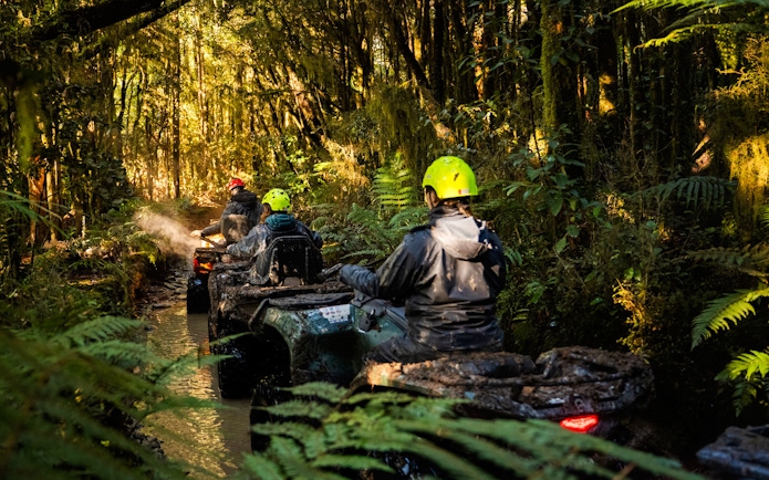 Quad biking through forest trail at Franz Josef, New Zealand.