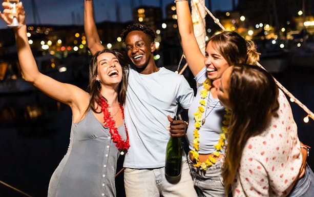 People celebrating at a New Year 2024 yacht party in Dubai.