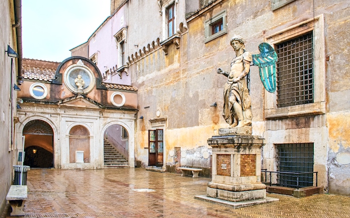 Statue and courtyard at Castel Sant'Angelo, Rome, with reserved entrance access.
