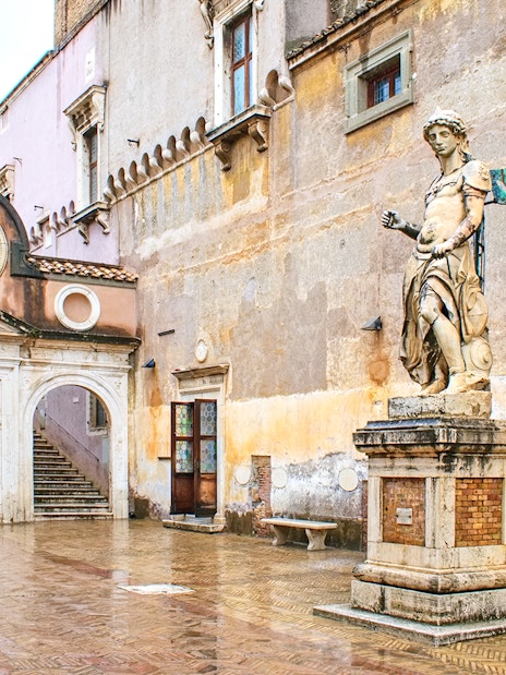 Statue and courtyard at Castel Sant'Angelo, Rome, with reserved entrance access.
