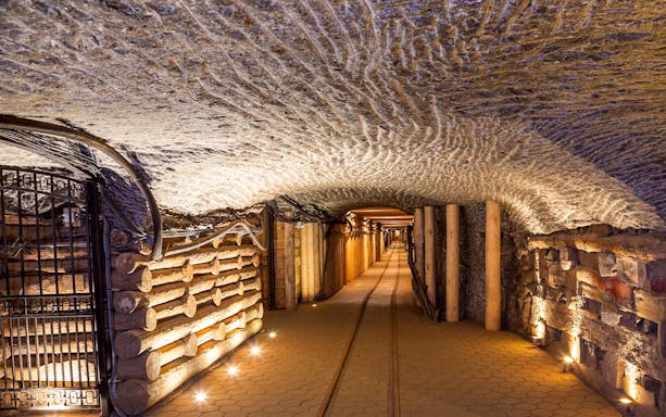 Wieliczka Salt Mine tunnel with illuminated walls and wooden supports, Poland.