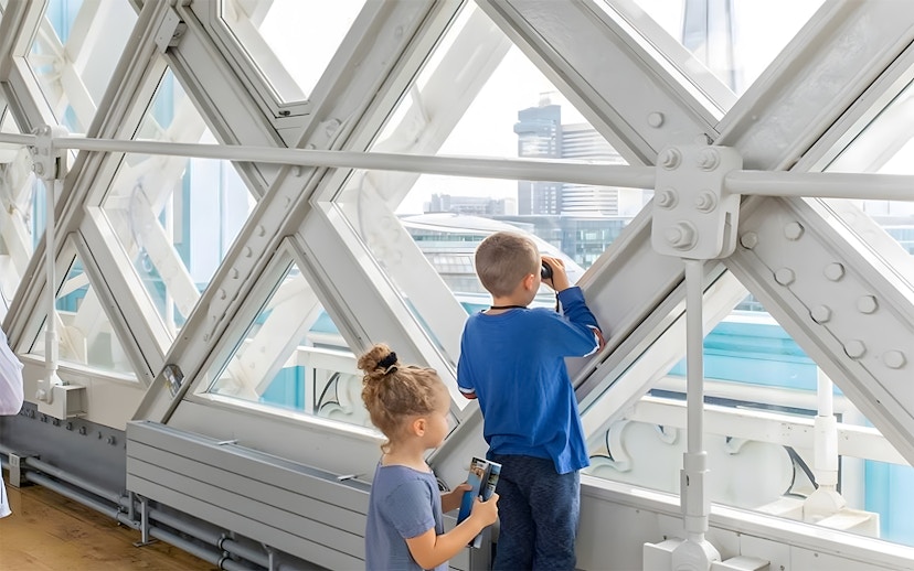 Children observing London skyline from inside Tower Bridge.