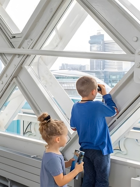 Children observing London skyline from inside Tower Bridge.