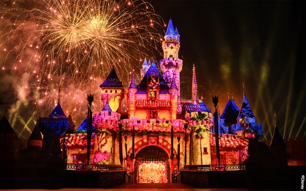 Fireworks illuminate Disneyland Castle at night in Disneyland Park, California.