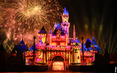 Fireworks illuminate Disneyland Castle at night in Disneyland Park, California.