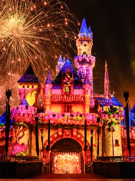 Fireworks illuminate Disneyland Castle at night in Disneyland Park, California.