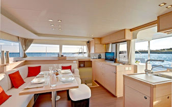 Luxury catamaran interior with dining area and ocean view.