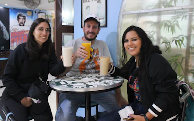 Group enjoying drinks at a cafe during Lucha Libre tour in Mexico City.